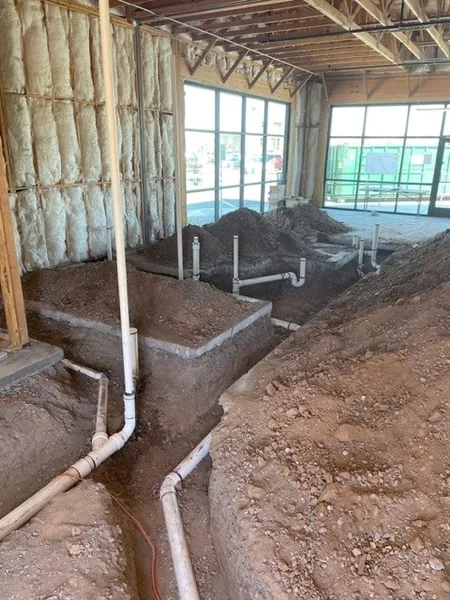 Drain pit with multiple PVC stub-outs and sand backfill at the slab stage of a new build