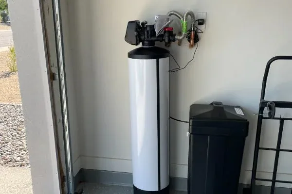 Whole-home water softener tank with brine tank in a clean garage install