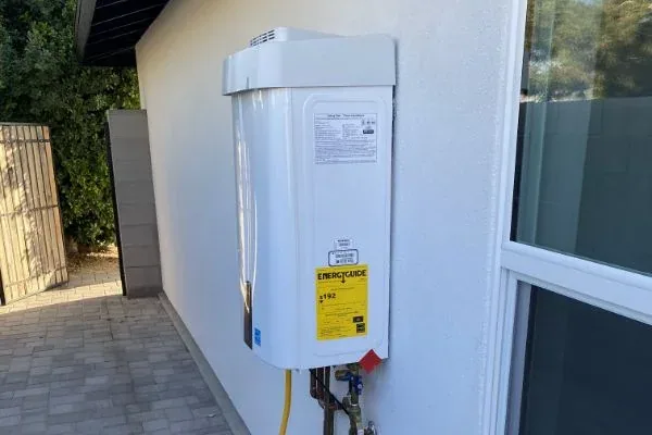 Tankless water heater with EnergyGuide label, exterior wall install
